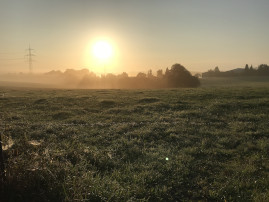 Landschaft mit Sonne im Hintergrund